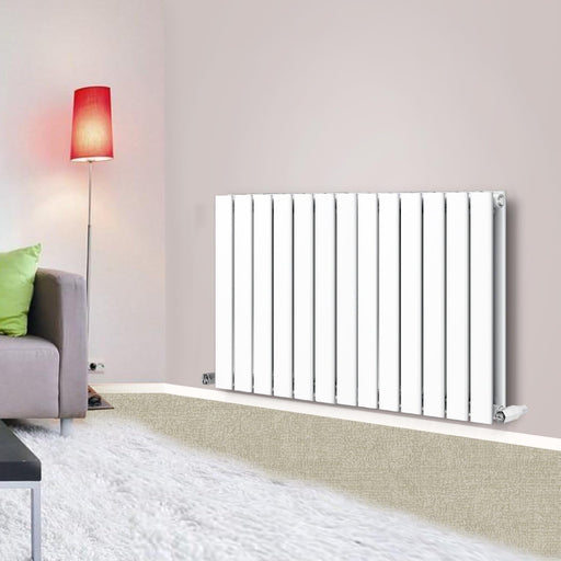 A horizontal designer radiator with flat panels, colored in white, mounted on a wall in a room with a modern decor. The radiator features a sleek, contemporary design with vertical bars.
