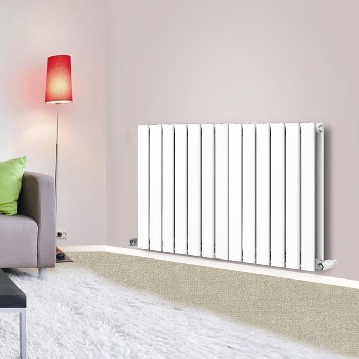 A horizontal designer radiator with flat panels, colored in white, mounted on a wall in a room with a modern decor. The radiator features a sleek, contemporary design with vertical bars.