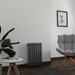 A modern horizontal column radiator in a living room setting, colored in a dark shade, anthracite, blending with the room's decor.